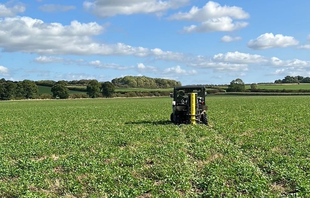 Agri Soil's ATV-mounted sampling rig working across a green cover crop under a bright sky